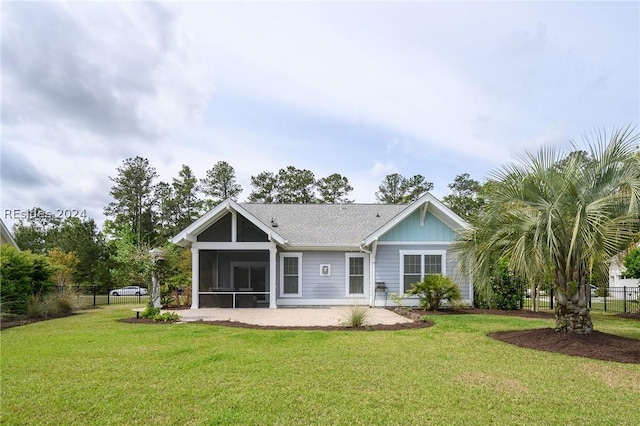 rear view of property with a sunroom and a lawn