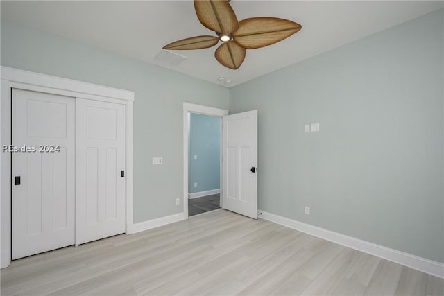 unfurnished bedroom with light hardwood / wood-style floors, ceiling fan, and a closet