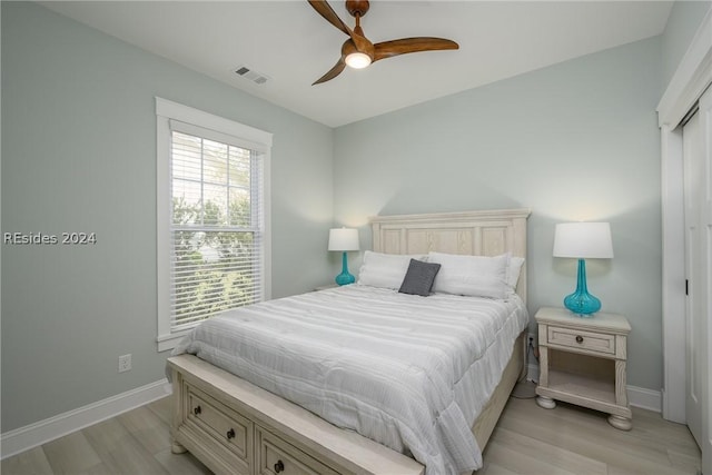 bedroom featuring ceiling fan, light hardwood / wood-style floors, and a closet