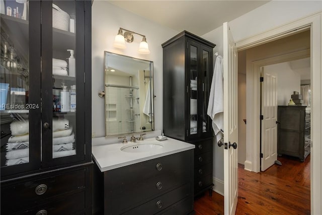 bathroom featuring vanity, wood-type flooring, and walk in shower