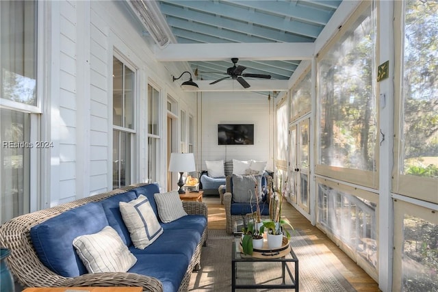 sunroom with ceiling fan, a healthy amount of sunlight, and vaulted ceiling with beams