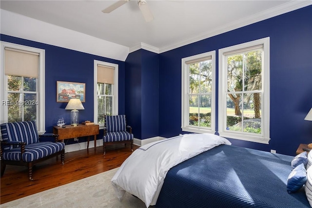 bedroom with wood-type flooring, crown molding, and ceiling fan