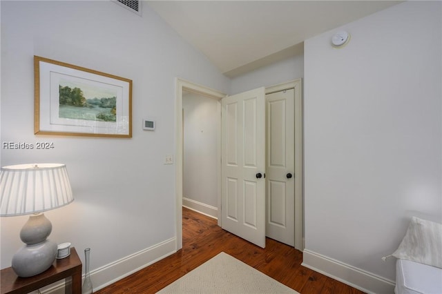 hall with dark hardwood / wood-style flooring and vaulted ceiling