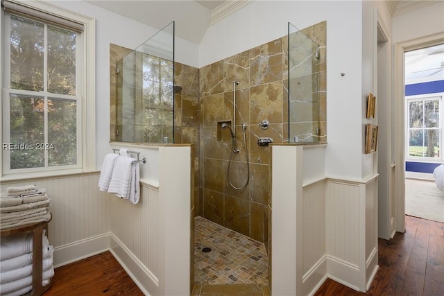 bathroom with hardwood / wood-style flooring, crown molding, and tiled shower