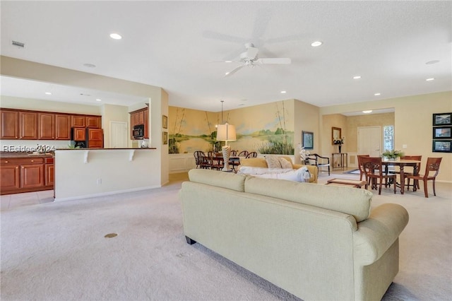 carpeted living room with ceiling fan