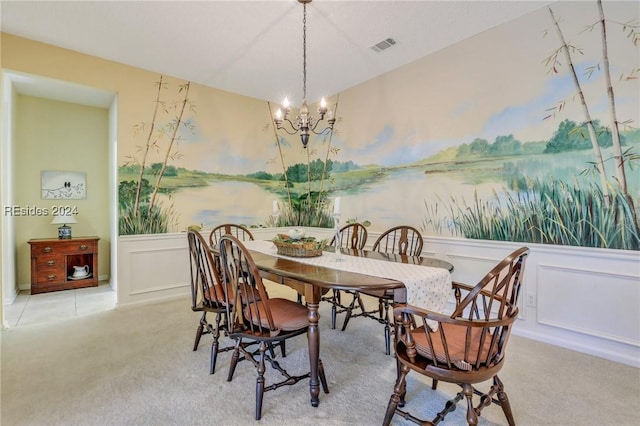 dining area with light carpet and a chandelier