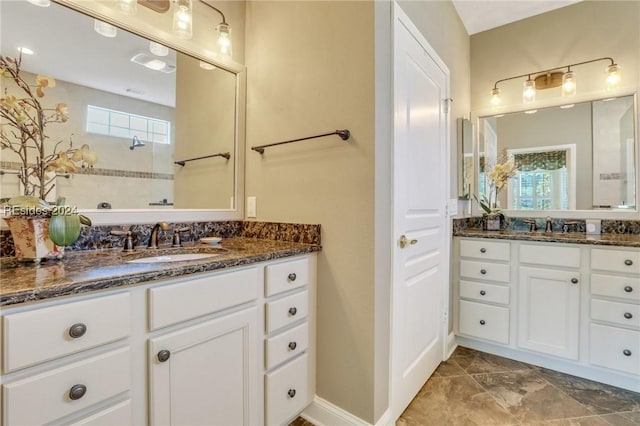 bathroom with a tile shower, vanity, and a wealth of natural light