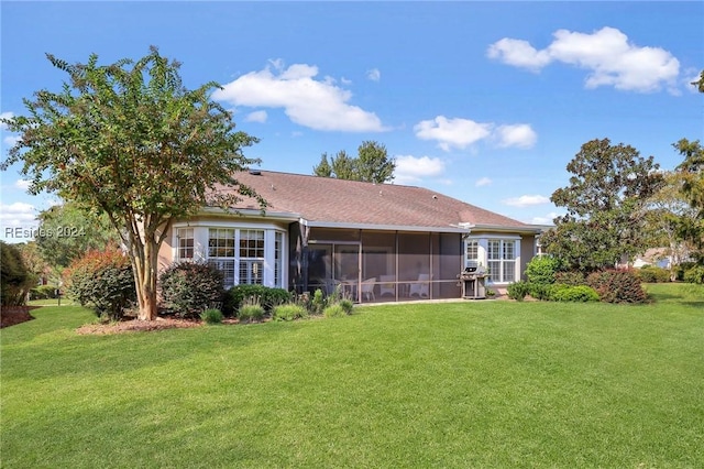 back of property featuring a lawn and a sunroom