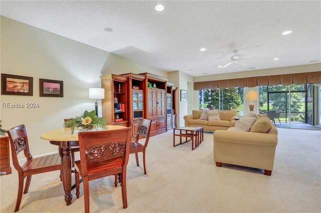 carpeted dining area featuring ceiling fan and a textured ceiling