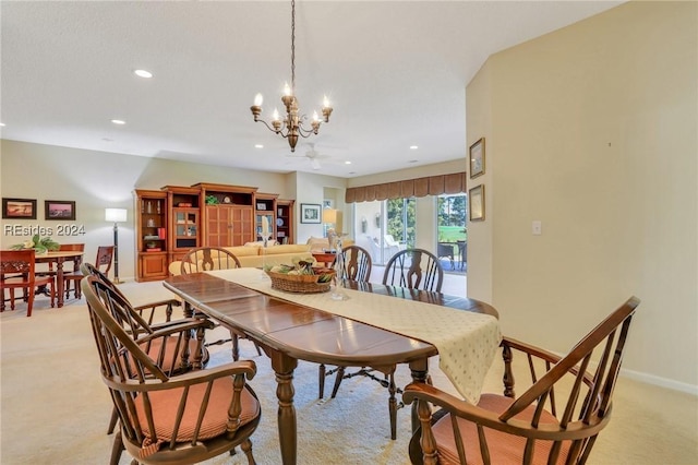 dining area featuring light carpet and a chandelier