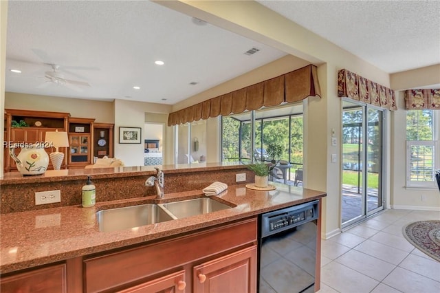 kitchen featuring sink, light tile patterned floors, dishwasher, light stone counters, and a textured ceiling