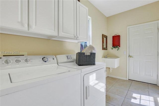 laundry area with light tile patterned floors, sink, washing machine and dryer, and cabinets