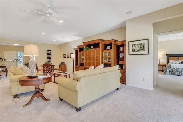 living room featuring light colored carpet and ceiling fan