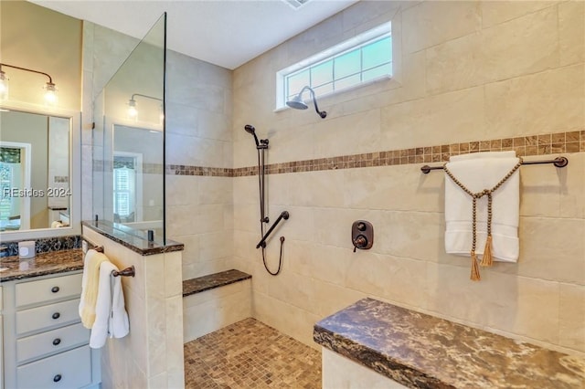 bathroom with vanity and tiled shower