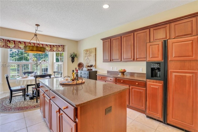 kitchen with hanging light fixtures, light tile patterned flooring, a kitchen island, and paneled built in fridge