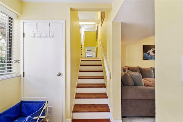 staircase featuring tile patterned flooring