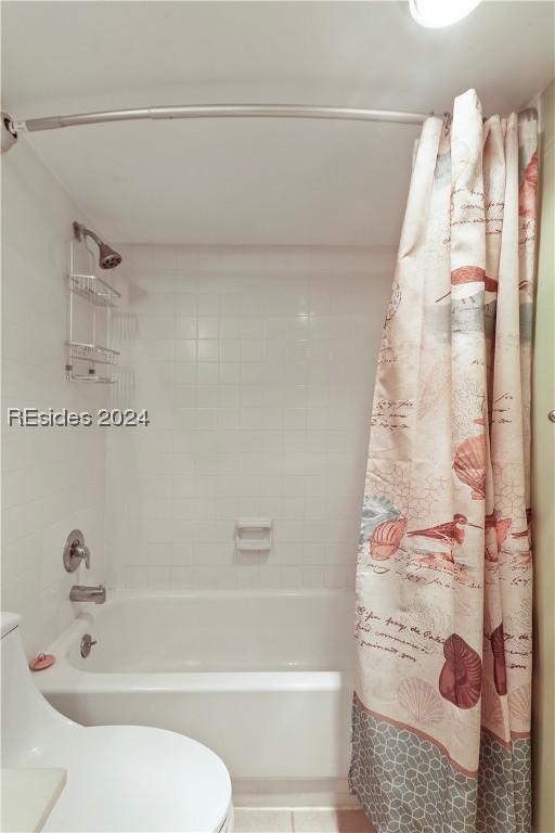 bathroom with shower / bath combination with curtain and toilet