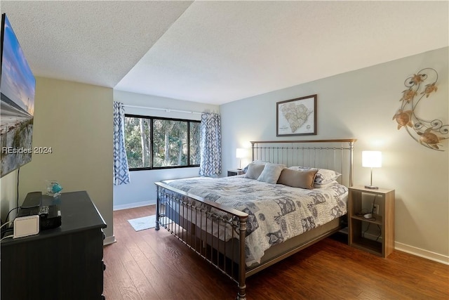 bedroom with dark wood-type flooring and a textured ceiling