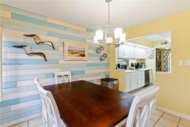 tiled dining area with a chandelier, sink, and wood walls