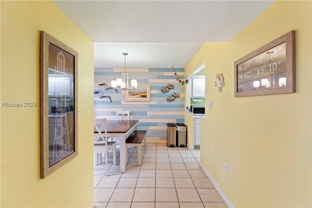 interior space featuring a notable chandelier, a textured ceiling, and light tile patterned floors