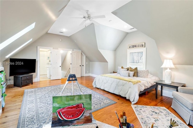 bedroom with hardwood / wood-style floors, vaulted ceiling, ceiling fan, and ensuite bathroom