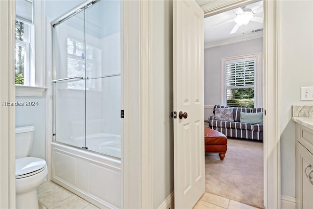 full bathroom featuring enclosed tub / shower combo, vanity, toilet, crown molding, and tile patterned floors