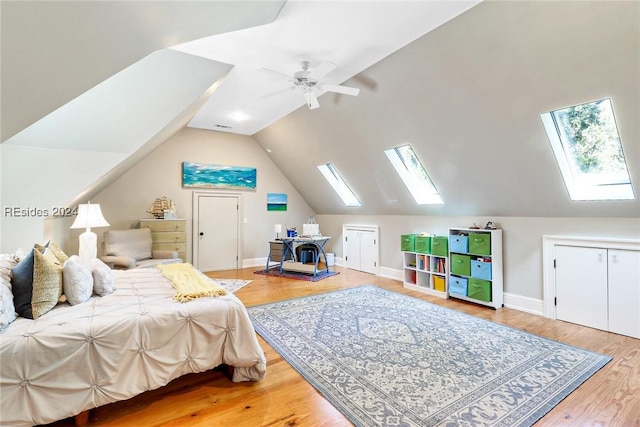 bedroom featuring wood-type flooring, lofted ceiling with skylight, and ceiling fan