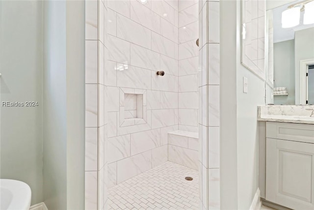 bathroom featuring tiled shower and vanity