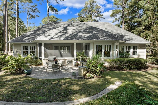 back of house with a lawn and a patio