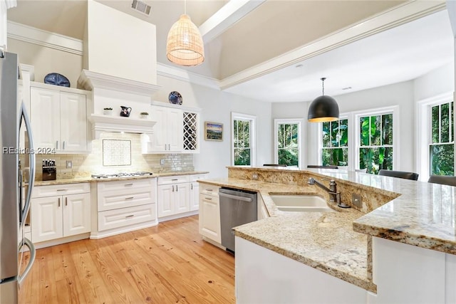 kitchen featuring stainless steel appliances, white cabinetry, and pendant lighting