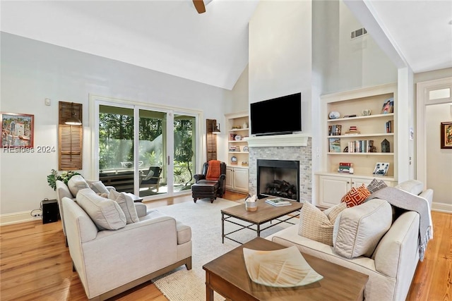 living room featuring light hardwood / wood-style flooring, high vaulted ceiling, and ceiling fan