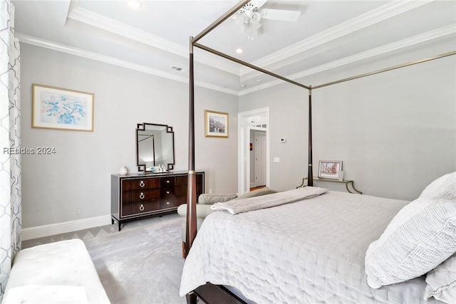 carpeted bedroom featuring a tray ceiling, ornamental molding, and ceiling fan