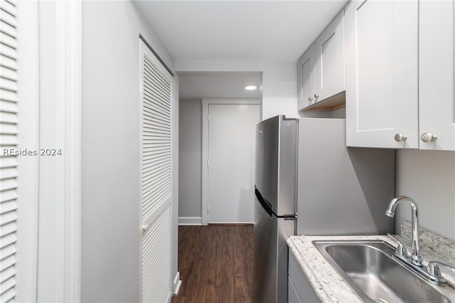 kitchen featuring white cabinetry, light stone countertops, sink, and dark wood-type flooring