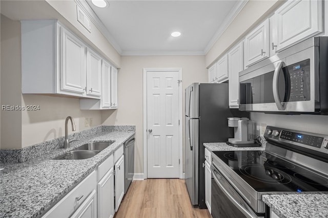 kitchen with white cabinetry, appliances with stainless steel finishes, sink, and crown molding