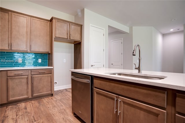 kitchen with dishwasher, sink, light wood-type flooring, and decorative backsplash