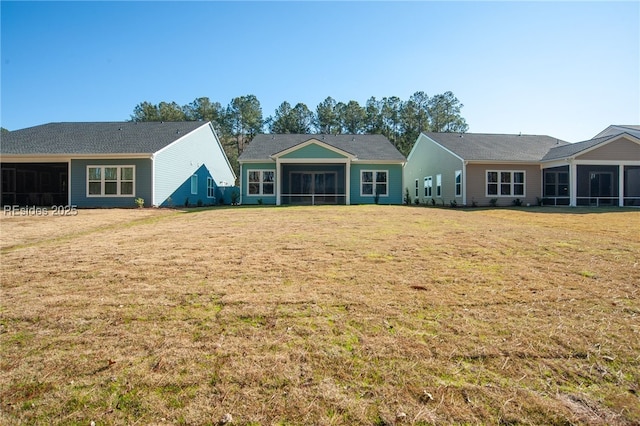 view of front of house featuring a sunroom and a front lawn