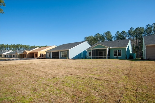 ranch-style house featuring a sunroom and a front lawn