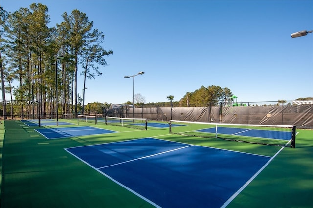 view of tennis court featuring basketball hoop