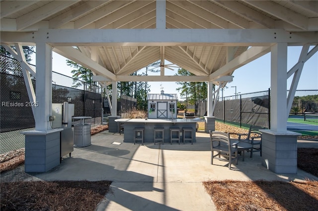 view of patio featuring a gazebo, exterior bar, and a storage unit