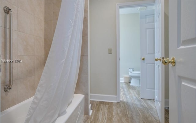 bathroom featuring shower / tub combo and toilet