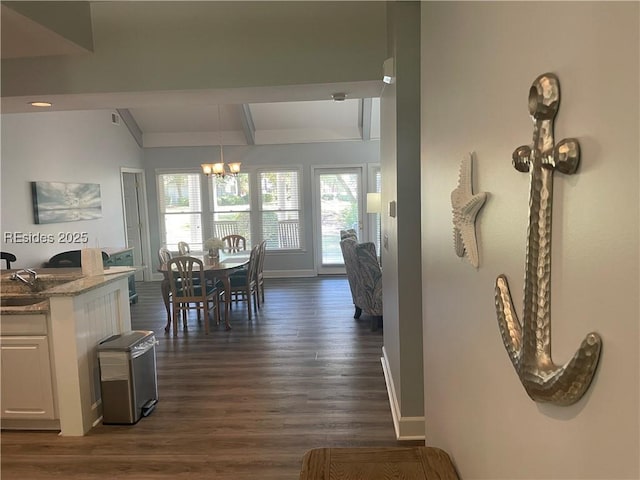 dining space with plenty of natural light, dark hardwood / wood-style flooring, a chandelier, and lofted ceiling with beams