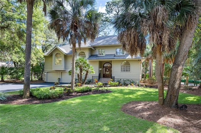 view of front of house with a garage and a front lawn