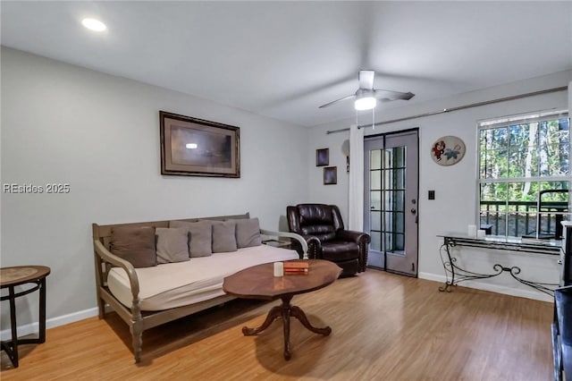 living room with light hardwood / wood-style flooring and ceiling fan