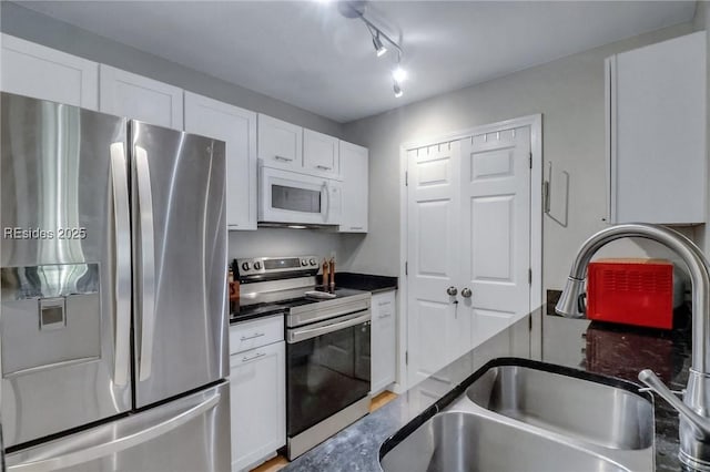 kitchen with white cabinetry, track lighting, appliances with stainless steel finishes, and sink