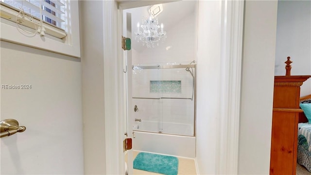 bathroom with an inviting chandelier and shower / bath combination with glass door