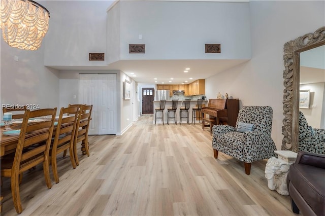 interior space with a high ceiling, an inviting chandelier, and light hardwood / wood-style flooring