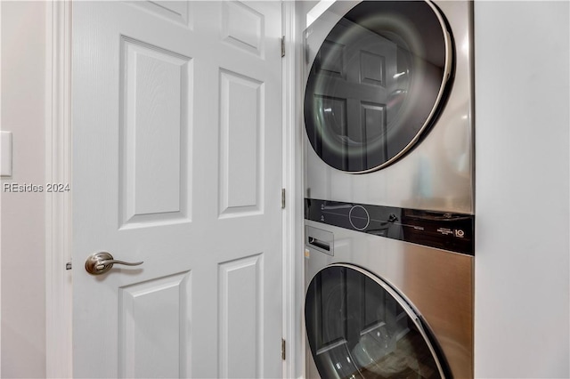 clothes washing area featuring stacked washer and clothes dryer