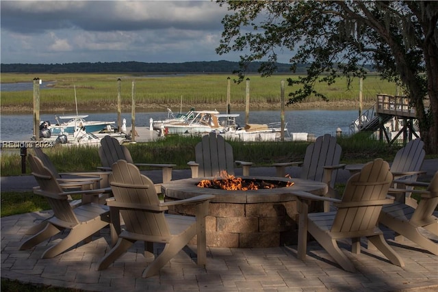 view of patio with a rural view, a fire pit, and a water view