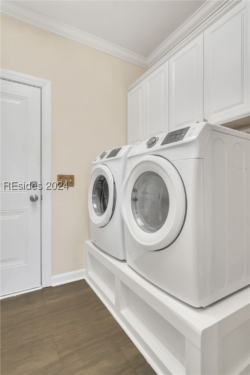 laundry area with cabinets, ornamental molding, dark hardwood / wood-style flooring, and washing machine and clothes dryer