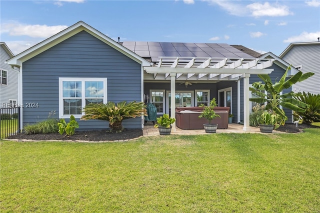 back of house featuring a hot tub, a pergola, and a lawn